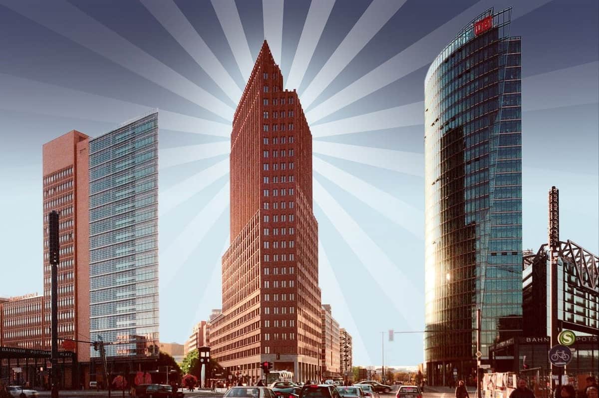 Panoramapunkt Berlin: Skip The Line Tall, narrow, red-brick skyscraper flanked by two modern glass buildings with sunburst pattern in background. Busy street below.