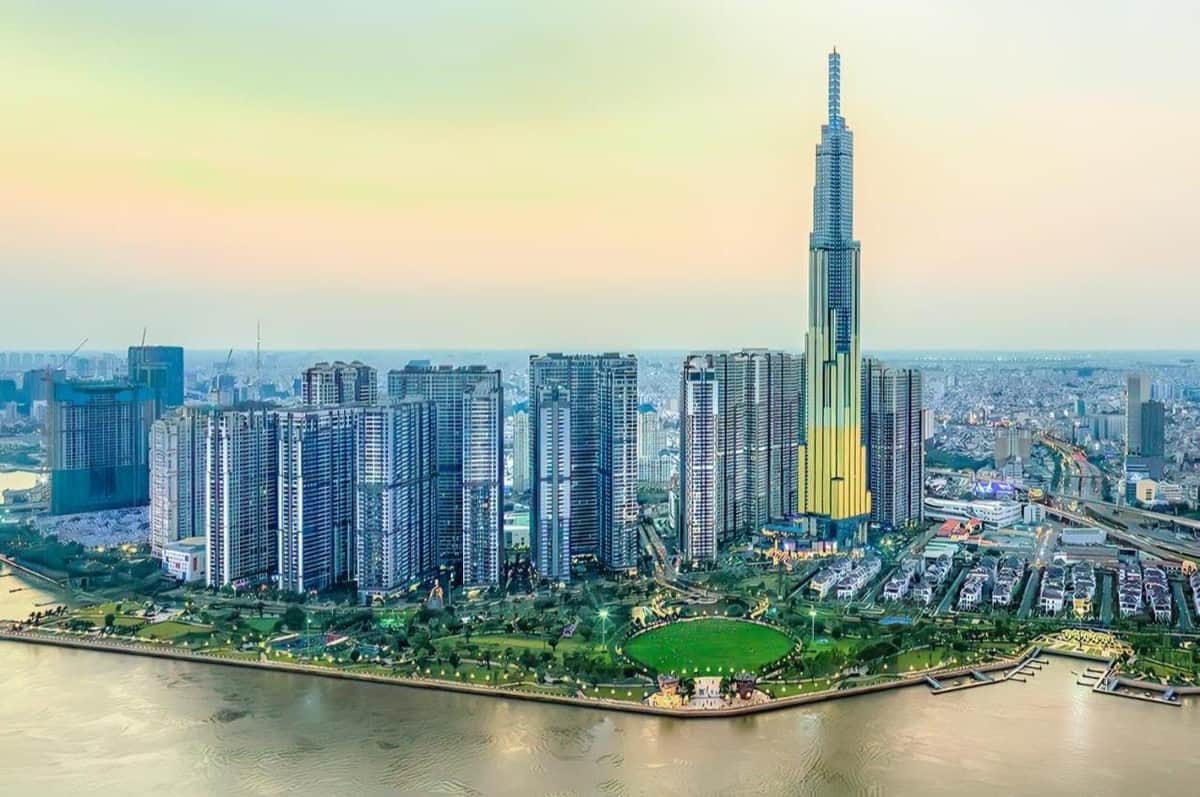 Landmark 81: SkyView Entry + VR Experience Cityscape with a river in the foreground, featuring a cluster of modern skyscrapers, including a prominent, tall building in the center.