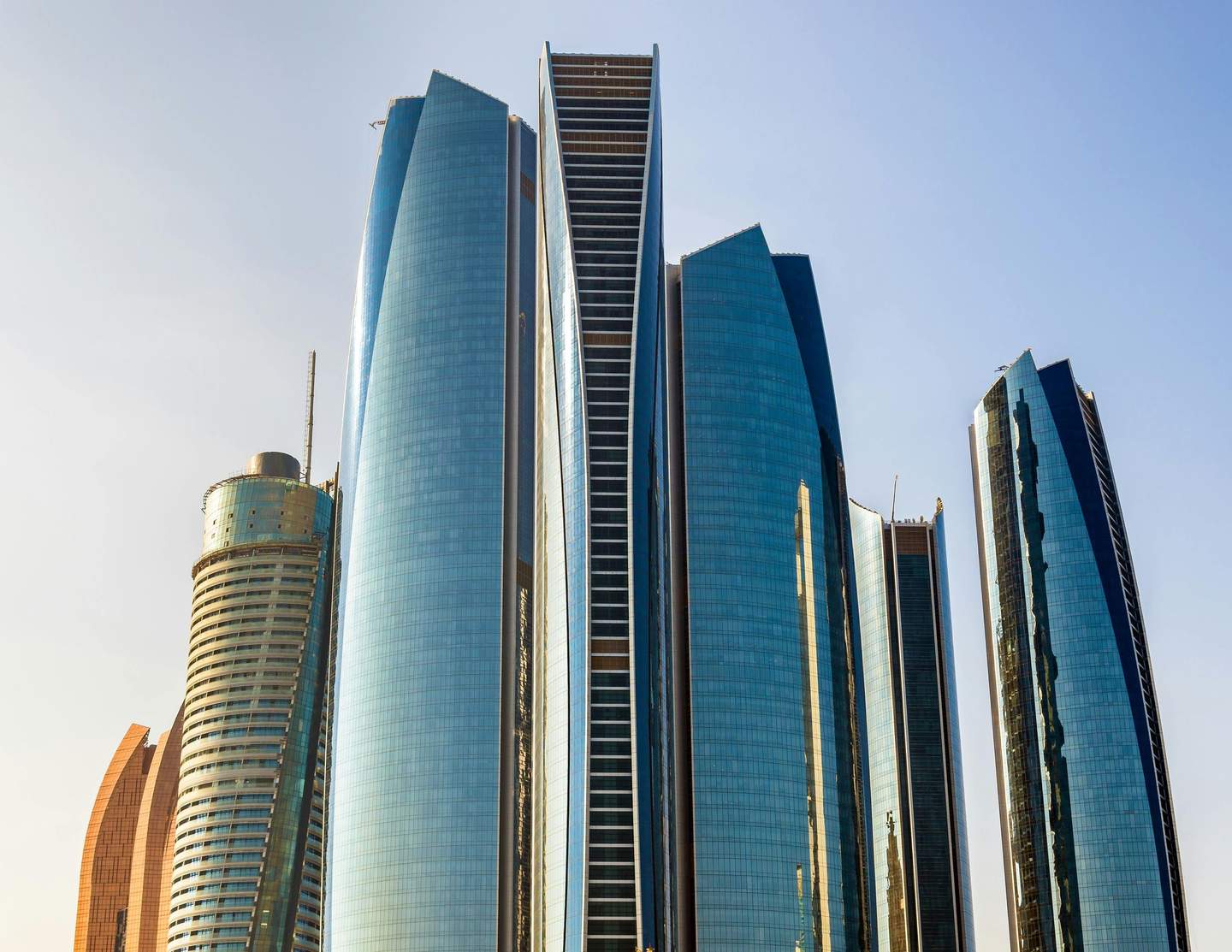 Etihad Towers - Observation Deck at 300 Cluster of modern skyscrapers with glass and steel facades under a clear blue sky.