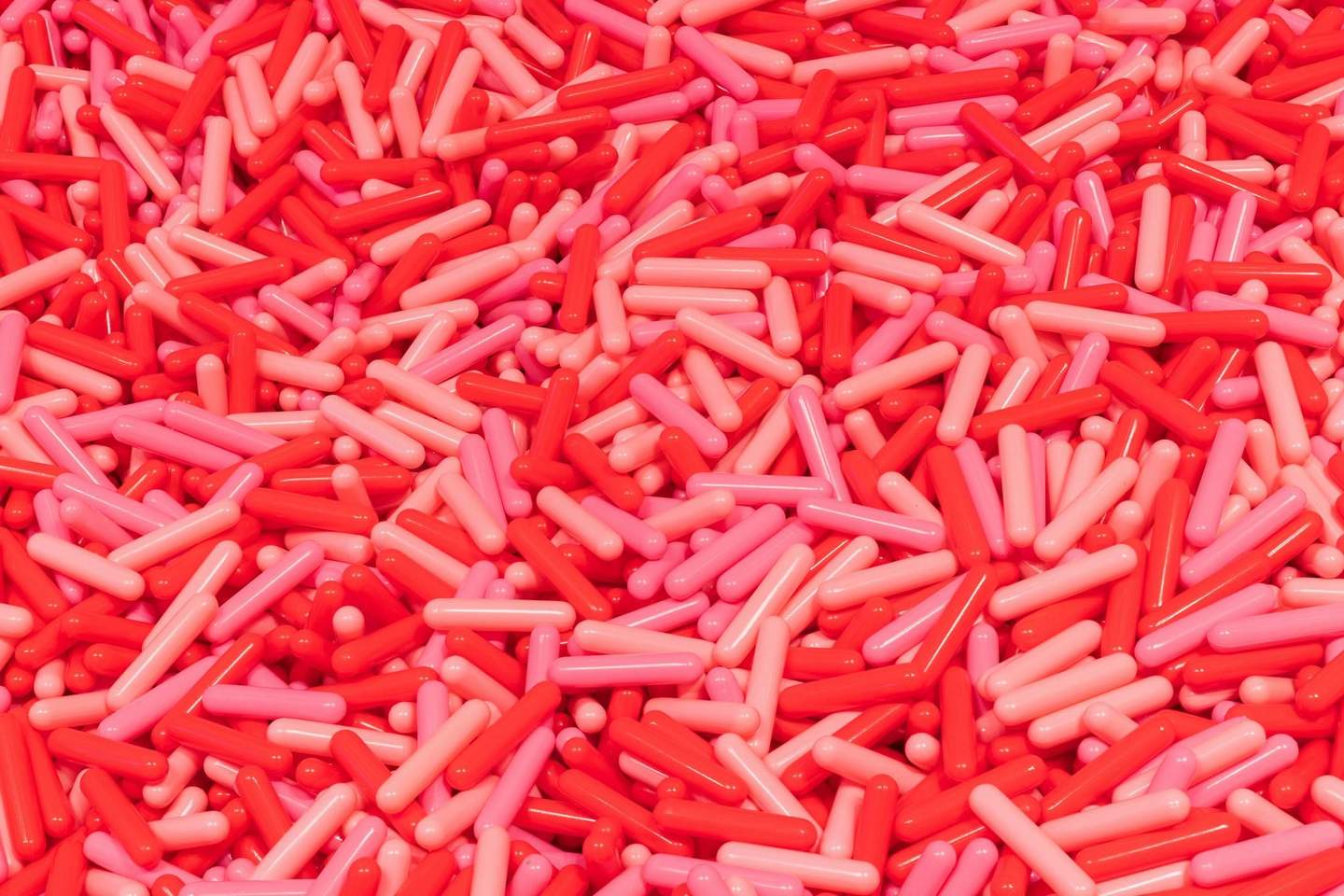 Museum of Ice Cream New York A large pile of red and pink capsule-shaped objects densely packed together.